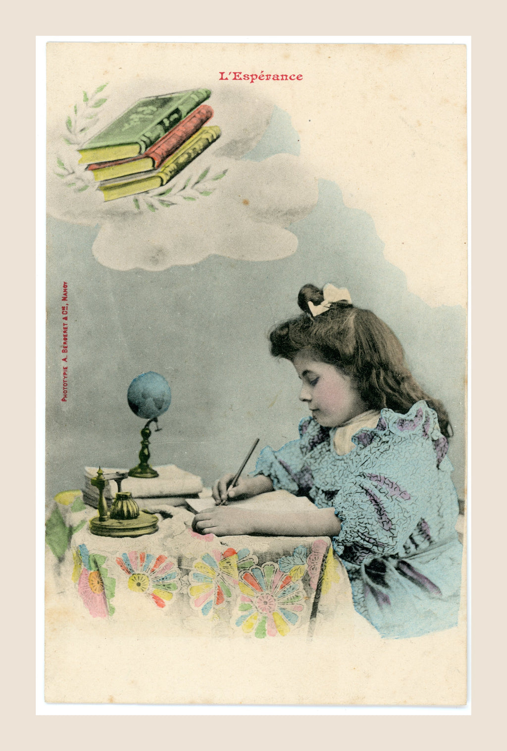 Antique French colorized Bergeret postcard L’Espérance, Hope, showing a young girl writing at a desk with books, globe and inkwell, Belle Époque circa 1905.
