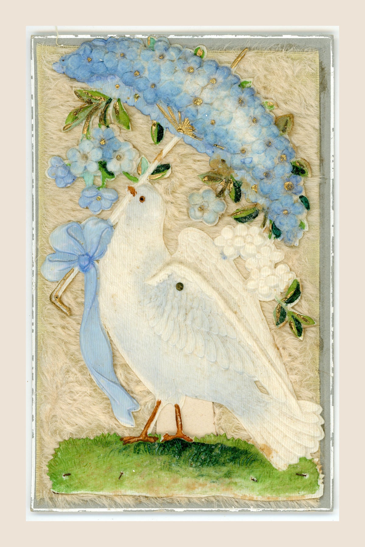 Antique postcard featuring a white dove beneath a parasol covered with blue fabric flowers, with a pale blue bow on a cream textile background.