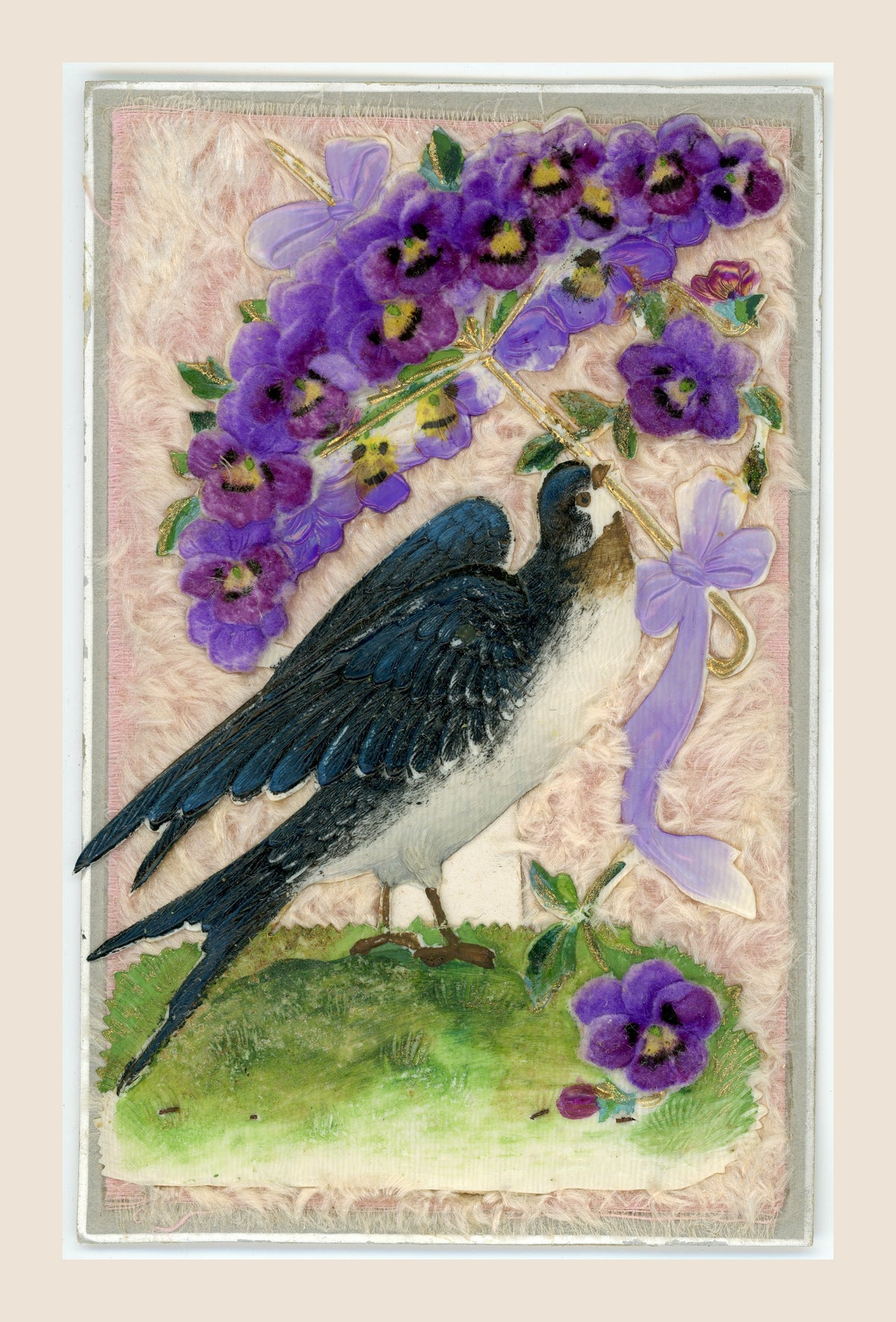 Antique postcard featuring a swallow beneath a purple fabric pansy parasol, with lilac bows and gold-toned details on a pale pink textile background.