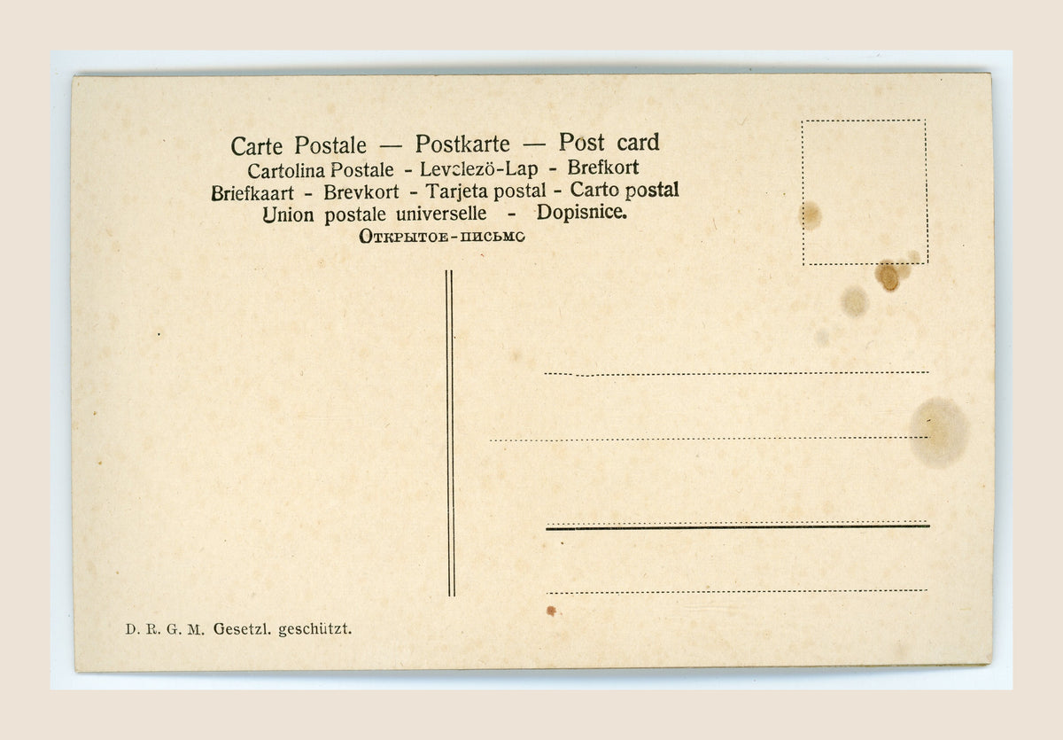 Unused reverse of an antique postcard with multilingual postal headings, D.R.G.M. marking, address lines and an empty stamp box, showing age toning and brown stains.