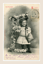 Antique Bergeret Les Voyelles postcard, letter E for Écolière, showing a smiling Belle Époque schoolgirl with satchel beside a floral letter E.