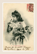 Antique Bergeret Les Cinq Sens L'Odorat postcard showing a young girl smelling a rose and holding flowers, with red French postage stamp.
