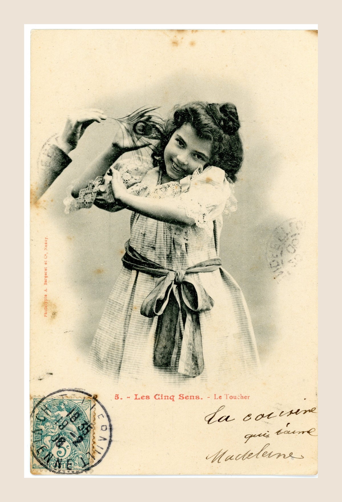 Albert Bergeret Les Cinq Sens Le Toucher antique postcard featuring a smiling young girl in a lace dress, with green postage stamp on the front.