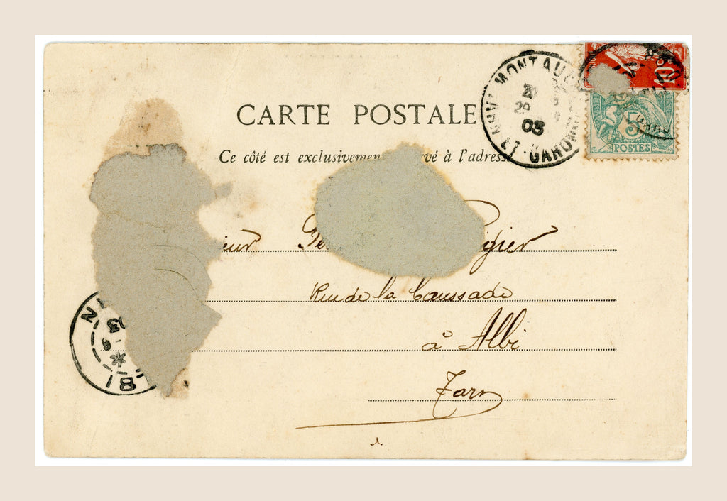 Reverse of an antique French Bergeret postcard with handwritten address, red and green postage stamps, 1903 Montauban postmark and visible paper loss.