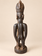 Rear view of Yoruba female Ere Ibeji wooden figure without cowrie cloak, showing carved back, arms and aged patina