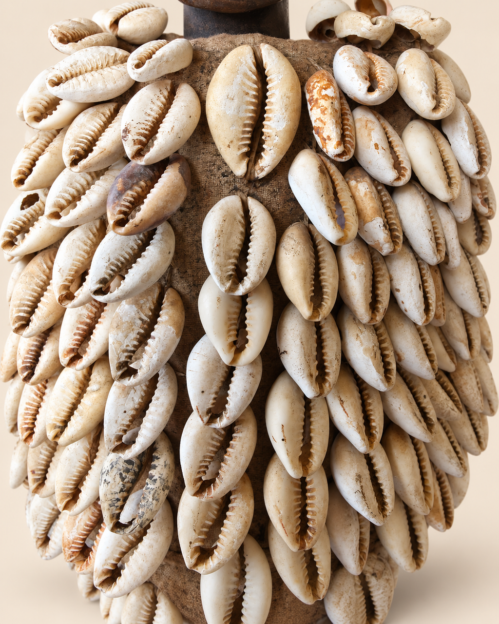Close-up of aged cowrie shells and antique textile on Yoruba Ere Ibeji cloak, showing natural wear and patina