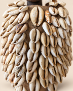Close-up of aged cowrie shells and antique textile on Yoruba Ere Ibeji cloak, showing natural wear and patina
