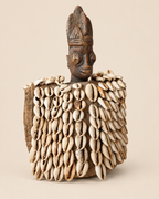 Three-quarter view of Yoruba Ere Ibeji figure with cowrie shell garment, Oyo region Nigeria