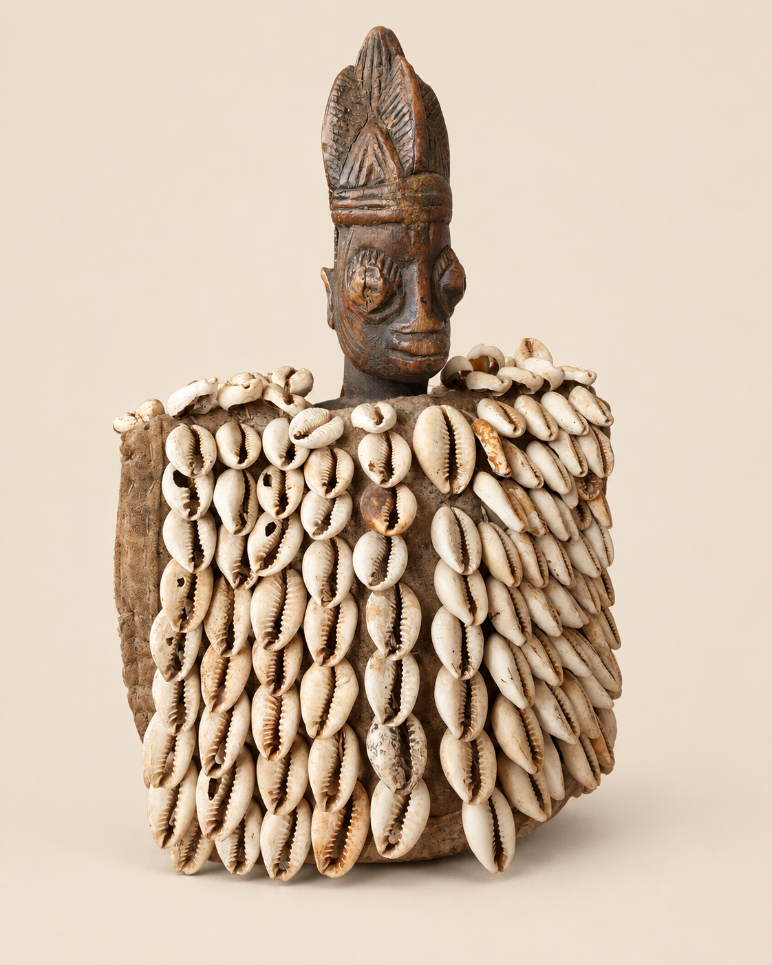 Three-quarter view of Yoruba Ere Ibeji figure with cowrie shell garment, Oyo region Nigeria