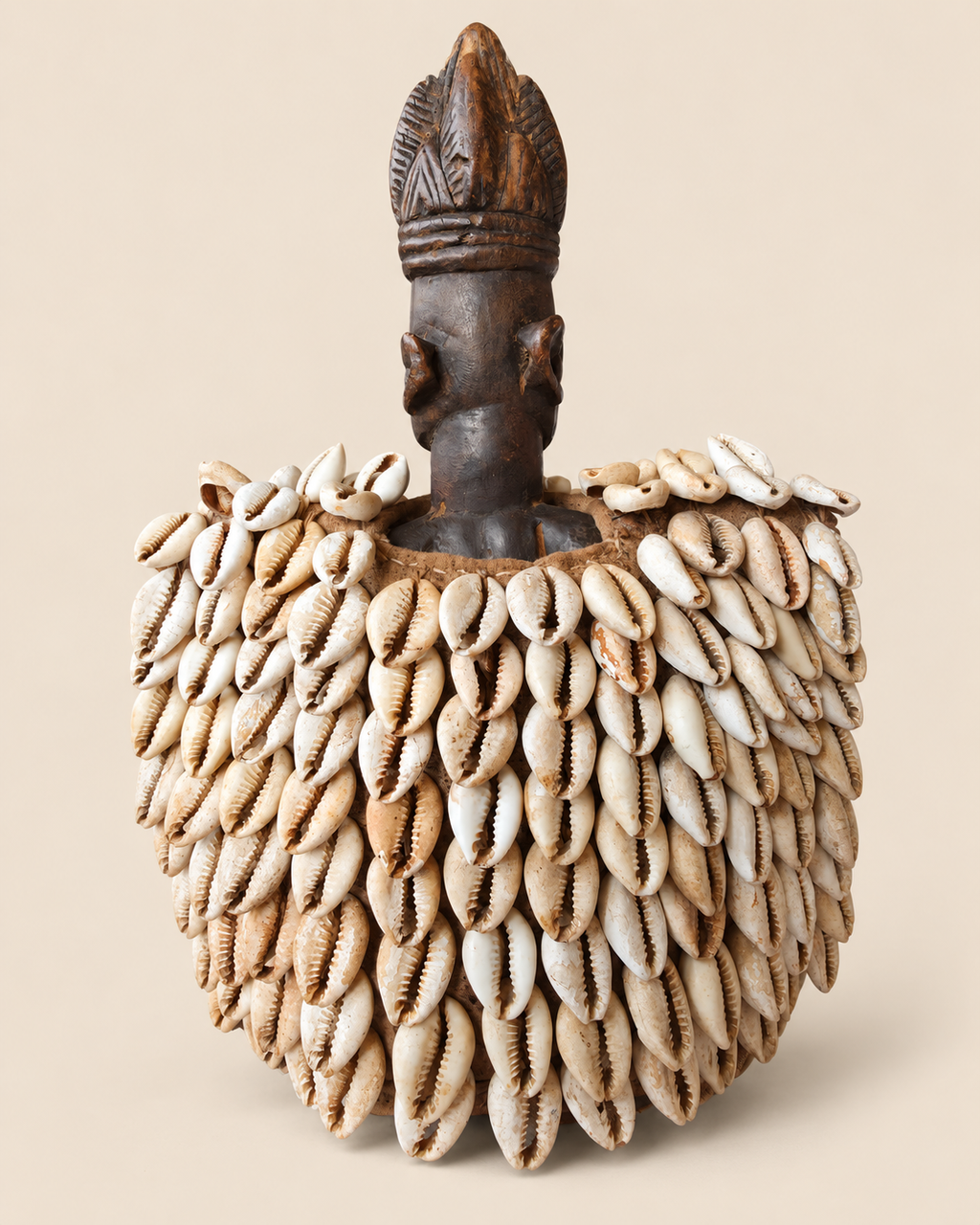 Rear view of Yoruba female Ere Ibeji with old textile cloak densely decorated with cowrie shells