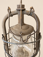 Close-up of the Panzer lantern’s metal chimney, folded carrying handle and upper glass globe, showing rust and age-related wear.