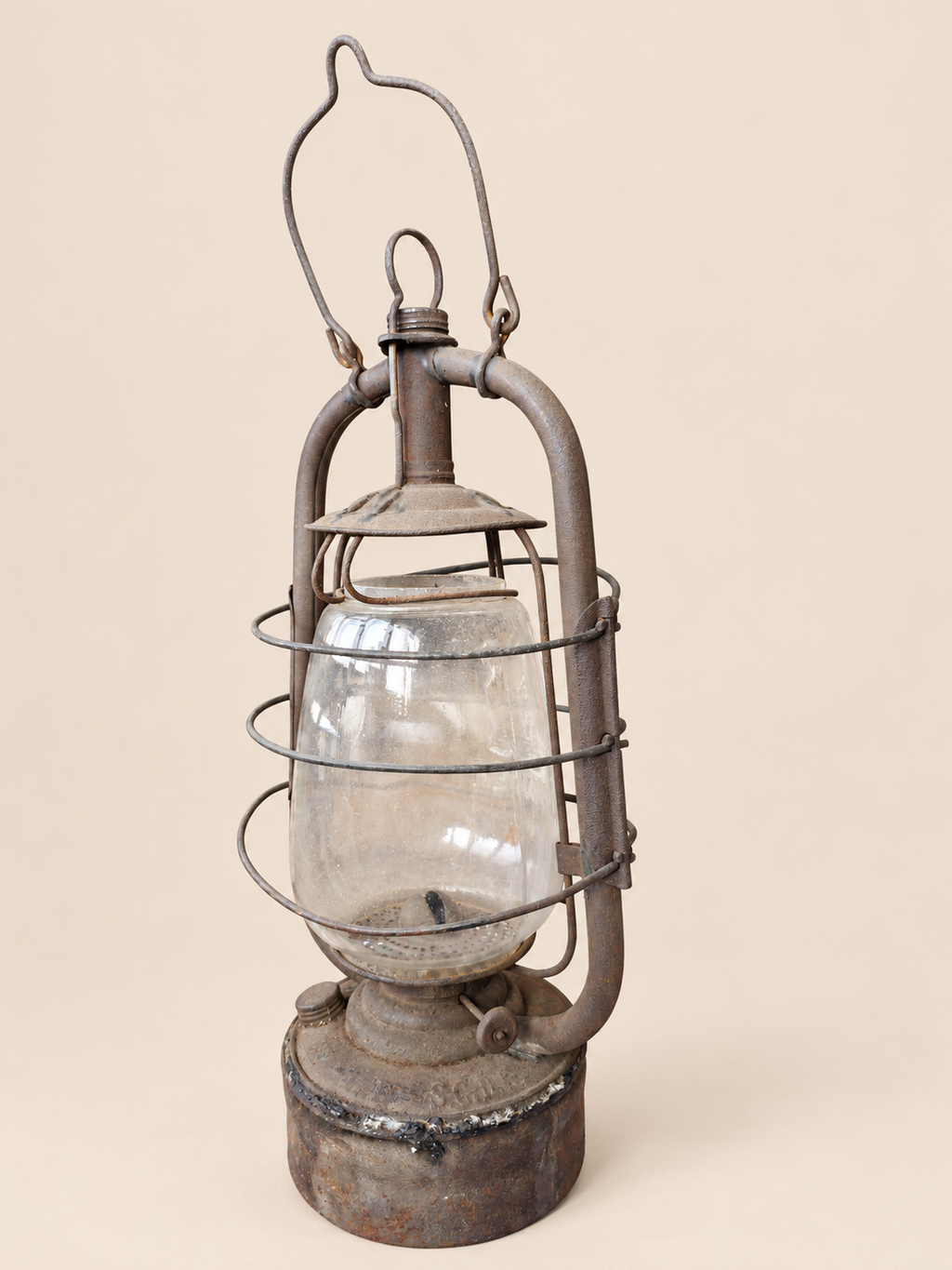 Rear three-quarter view of a vintage Panzer lantern, showing the protective wire cage, wick adjustment wheel and reservoir seam.
