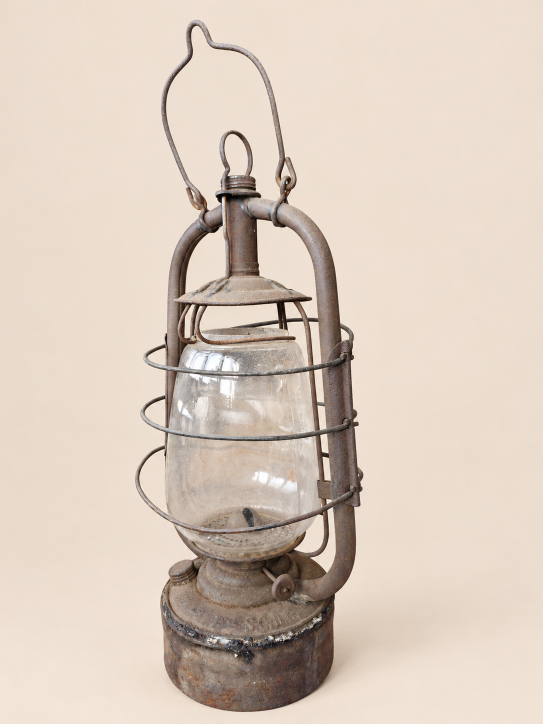 Rear three-quarter view of a vintage Panzer lantern, showing the protective wire cage, wick adjustment wheel and reservoir seam.