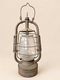 Front view of a vintage Panzer Cuirass hurricane lantern with raised handle, embossed glass globe and aged metal frame.