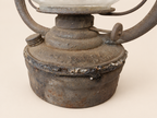 Close-up of the Panzer lantern’s rusted metal reservoir, showing an irregular solder seam, filler cap and wick adjustment wheel.